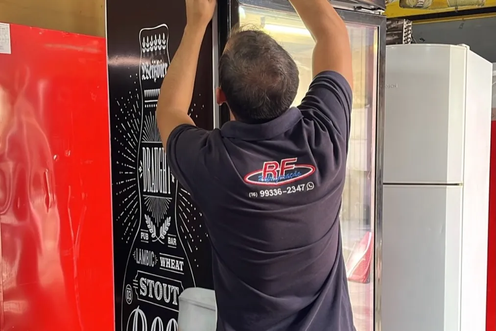 Técnico da RF Refrigeração consertando uma cervejeira em um bar