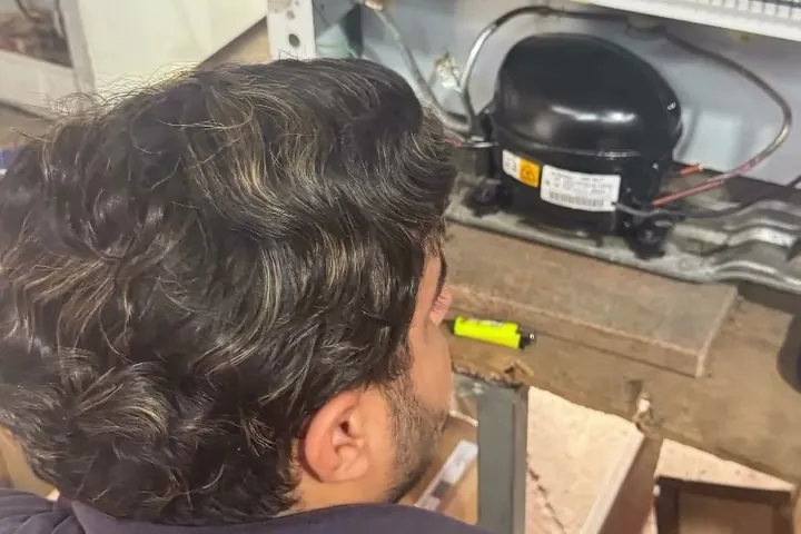 Técnico trocando o compressor de um equipamento de refrigeração